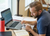 man studying with laptop and bible