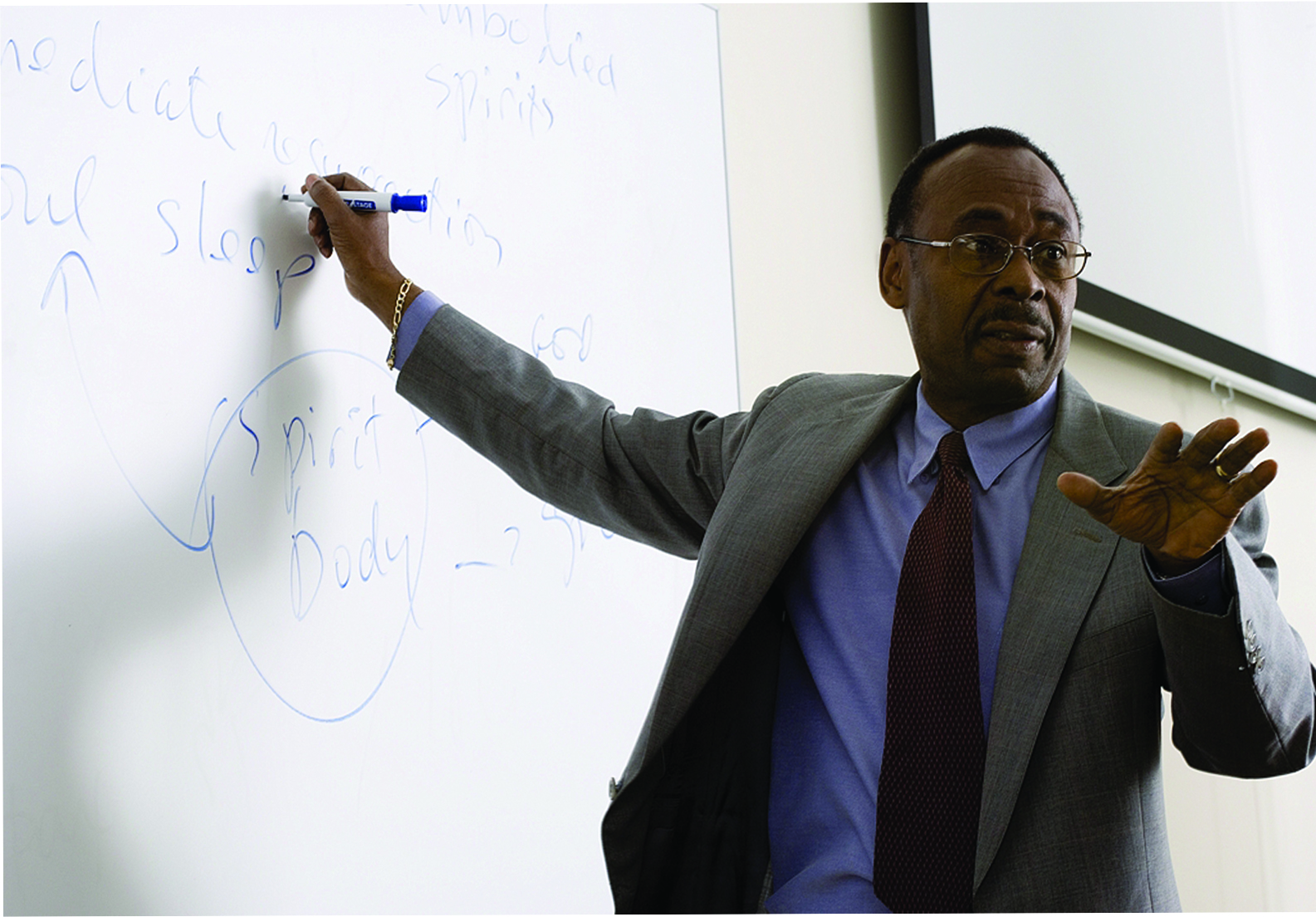 Black Denver faculty member standing at whiteboard