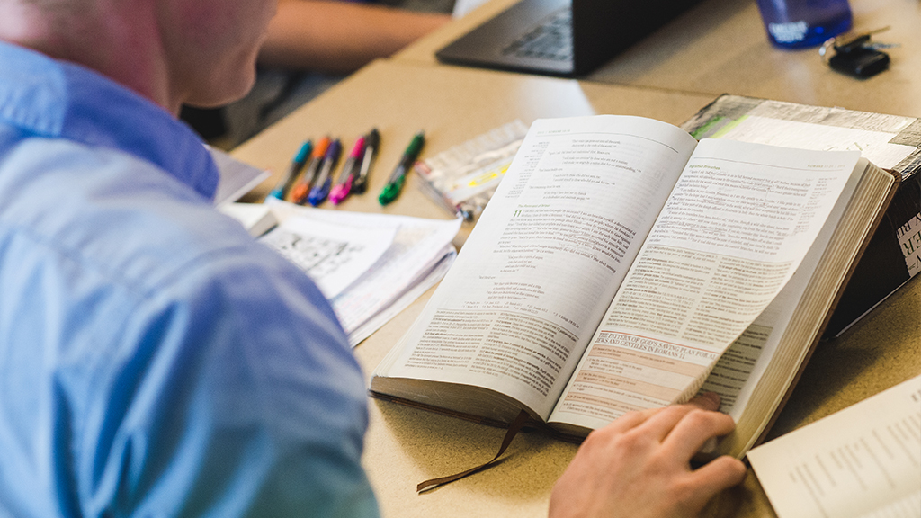 man turning page of bible