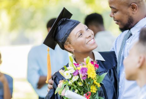 graduate smiles at husband after ceremony