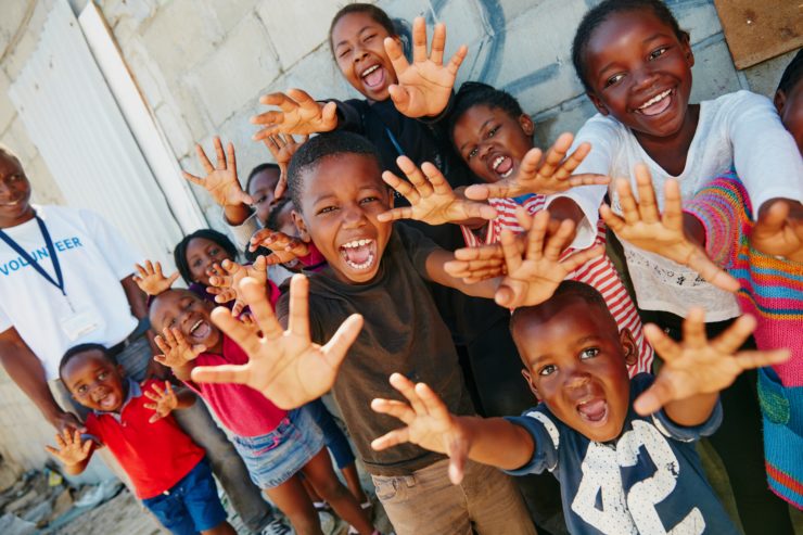 group of children holding out hands and smiling