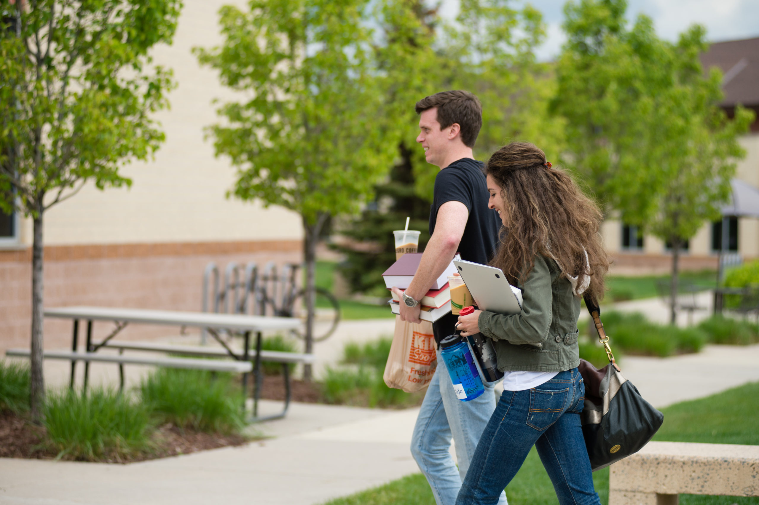 man and woman walking and talking on campus