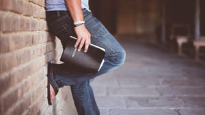 person holding bible waist down view