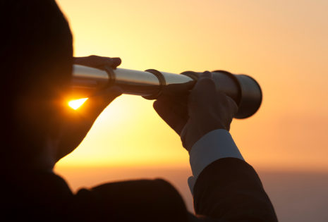 person looking into sky with telescope