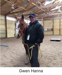 Woman holding reins of a horse inside a barn