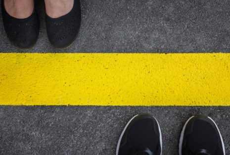 two pairs of shoes facing each other across yellow line on road